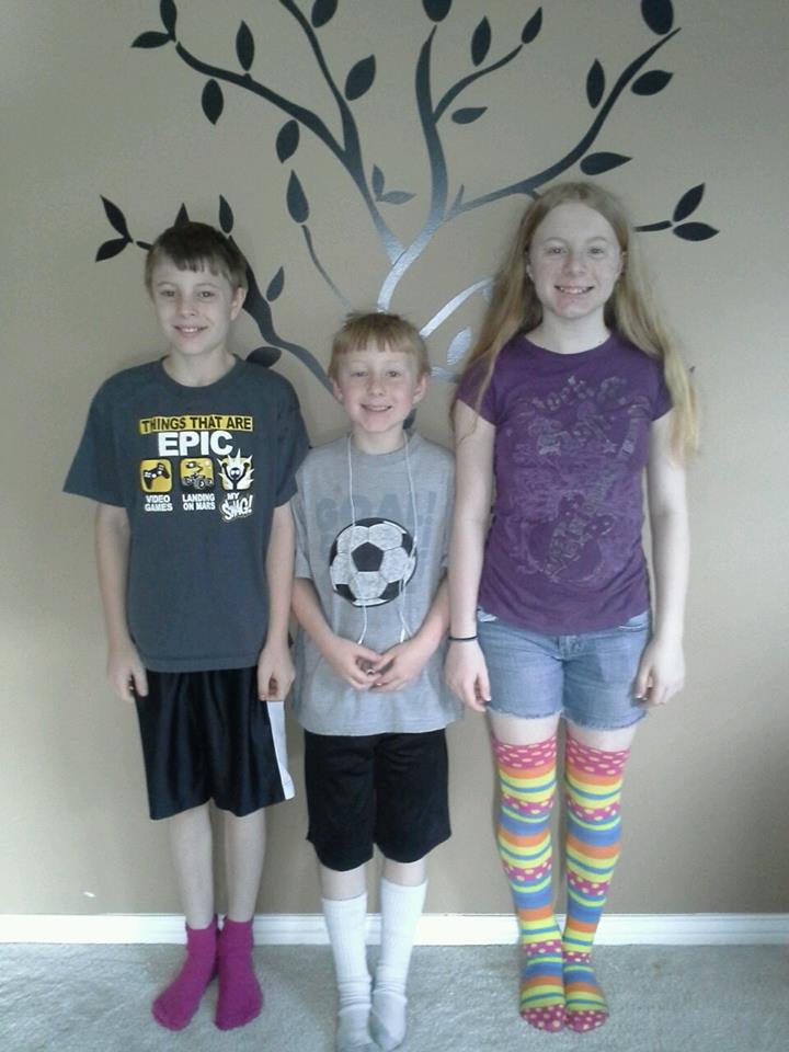 Three children by an indoor wall tree