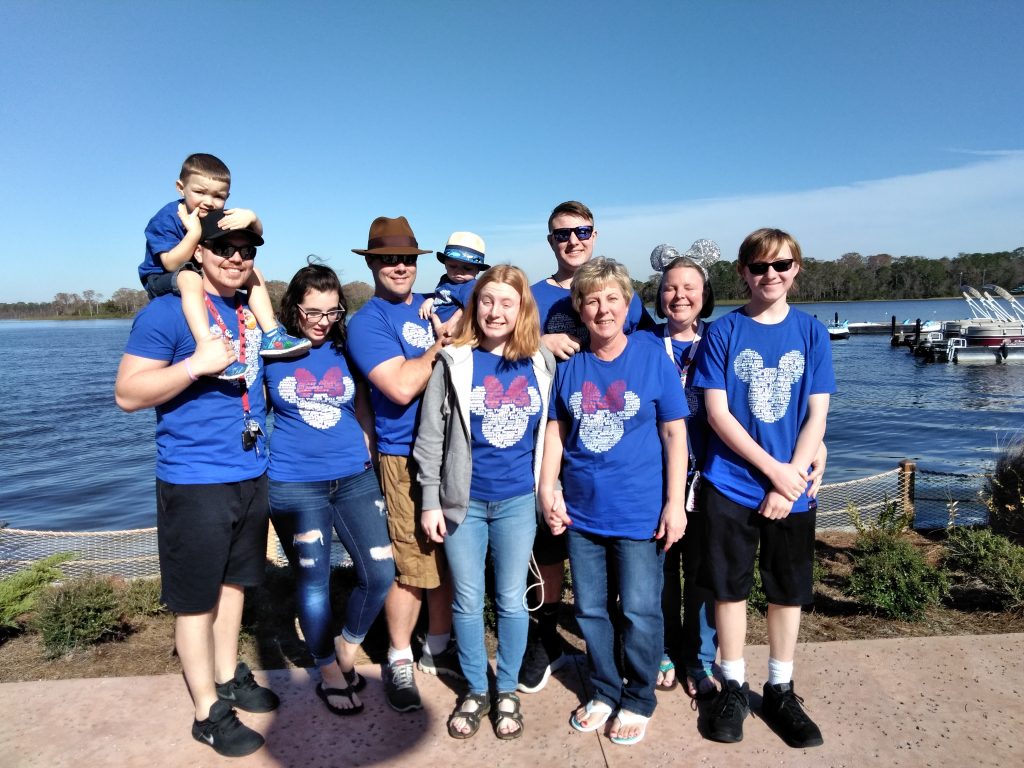 Family of four generations in matching shirts overlooking a body of water