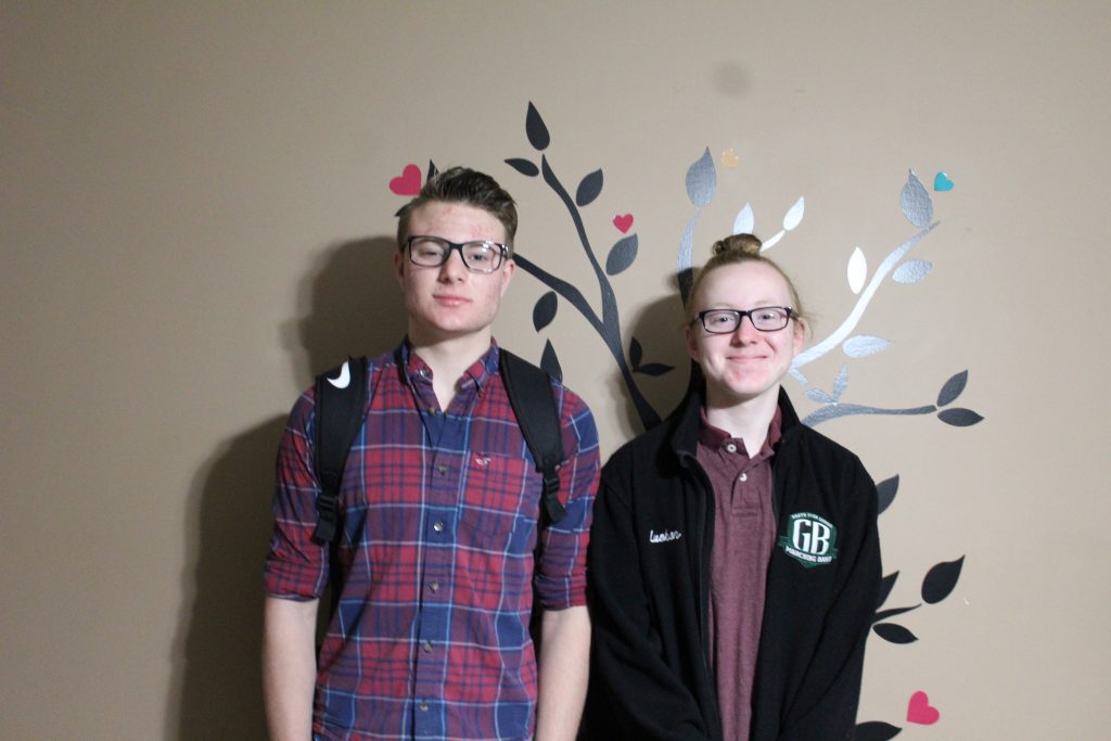 Two Adolescent boys staying in front of a wall tree on the last day of school 2019