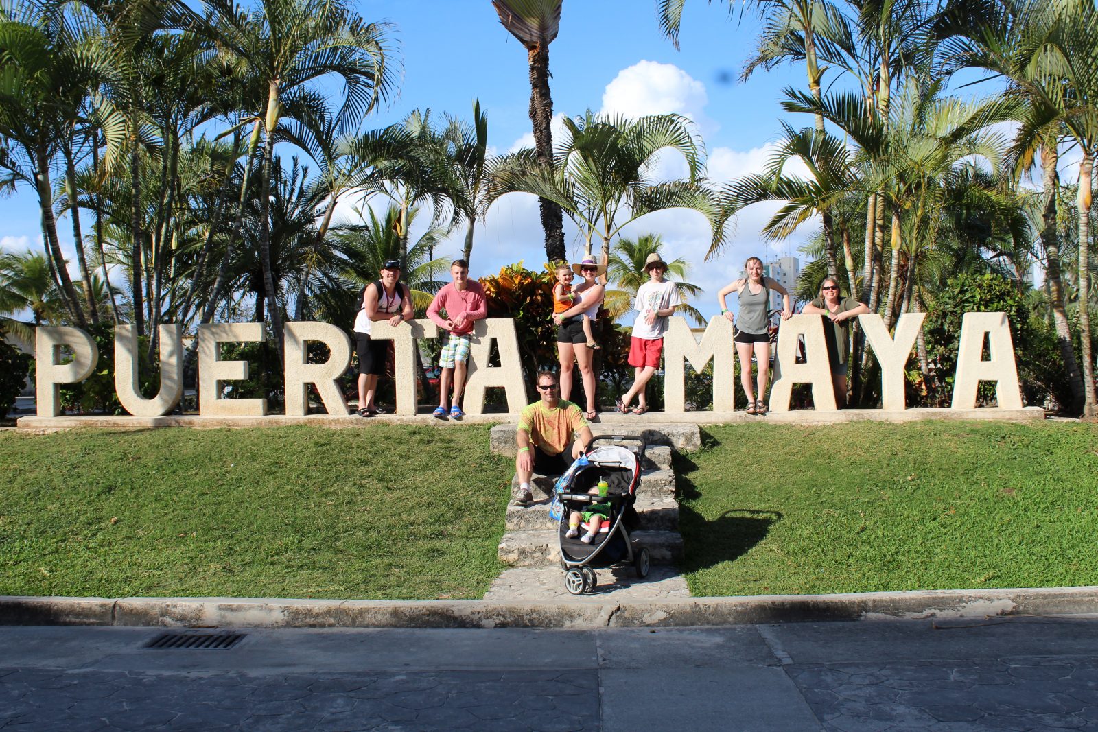 Three generations of family members in front of Puerta Maya sign