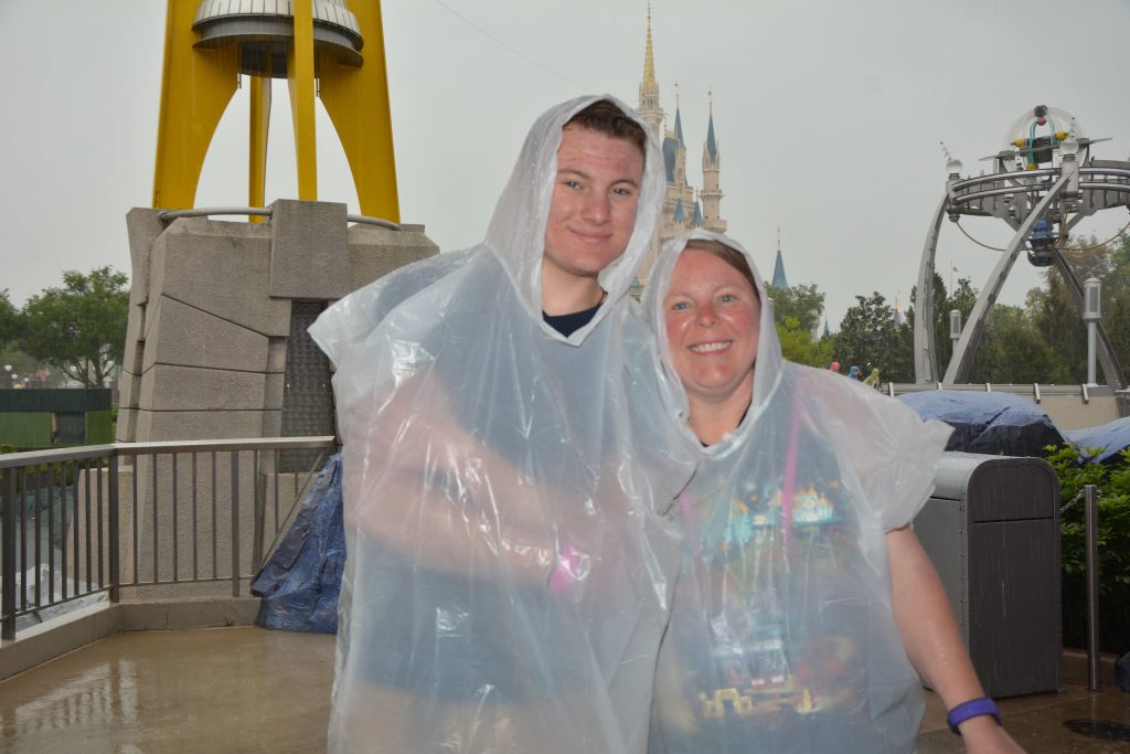 Mom and son in ponchos on a rainy day in Walt Disney World's Magic Kingdom