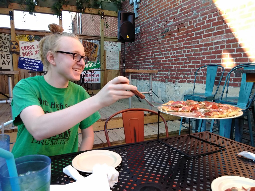 Franklin Street Pizza Factory boy with pizza on outside patio