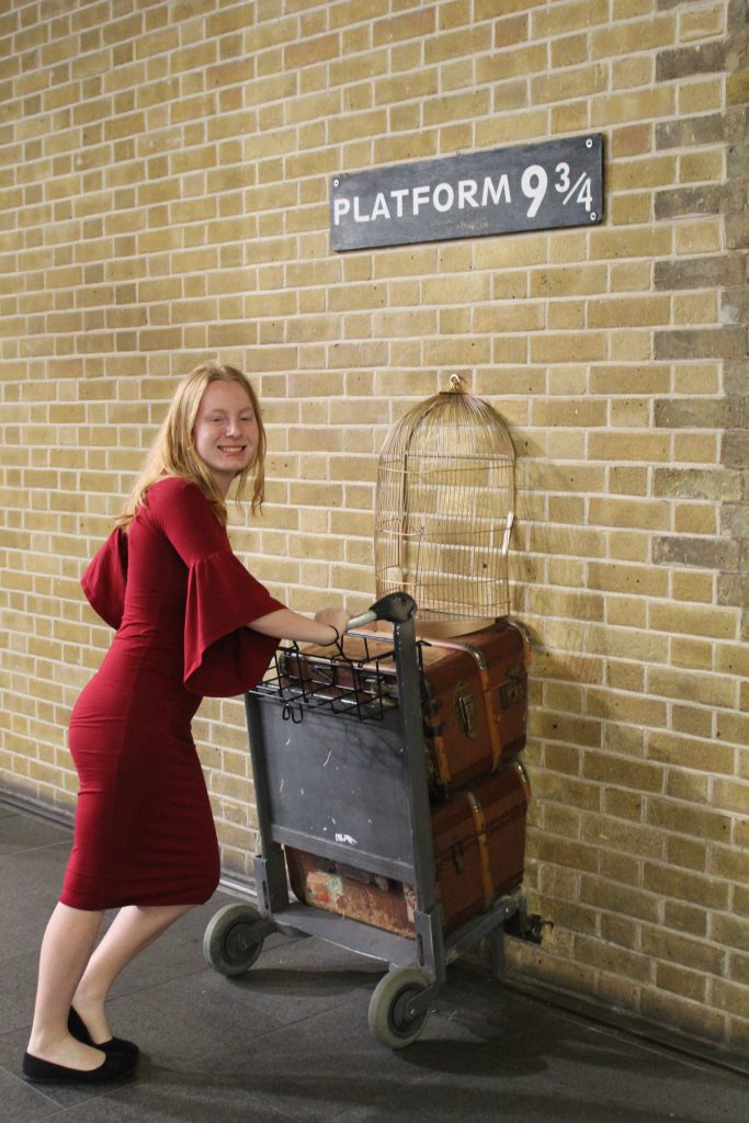 Teen girl at platform 9 3/4 in London, England