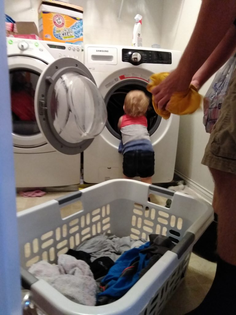 toddler helping with laundry