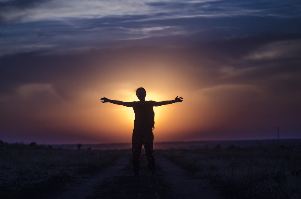 silhouette of a human in full-length in the rays of the sunset